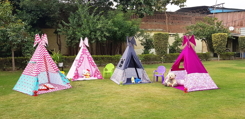 four teepee tents set up in a garden for kids slumber party