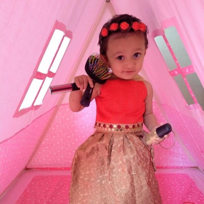 A-Shape kids tent in pink color with a girl standing inside the tent
