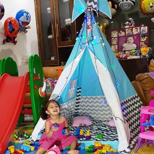A girl enjoying her teepee slumber party showing some Fun sleepover games for kids